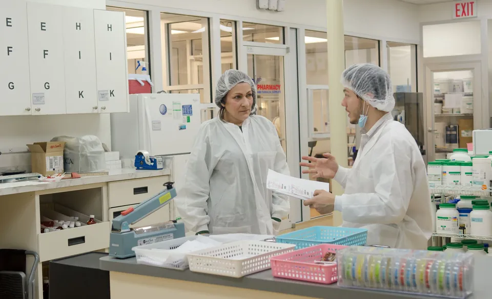 Deux collaborateurs en tenue d’hygiène échangent dans un atelier agroalimentaire